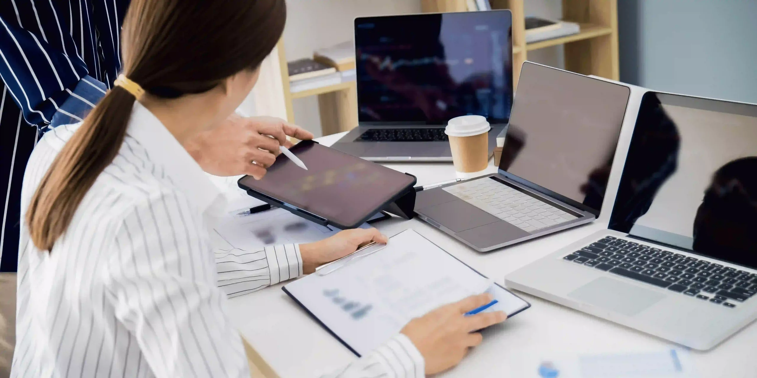 2 pessoas numa mesa com computadores e mapas a analisar propostas de apoio às empresas