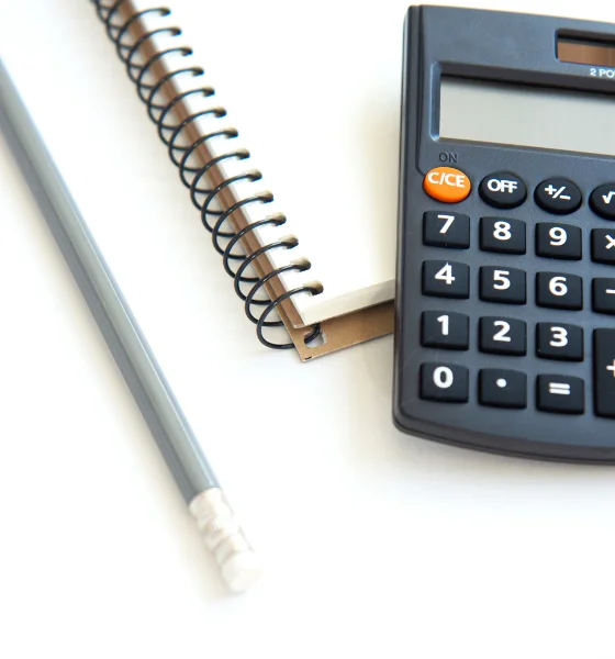 Lápis, Caderno de notas e uma calculadora para retratar os serviços de estratégia empresarial da Incentiva+ Consulting